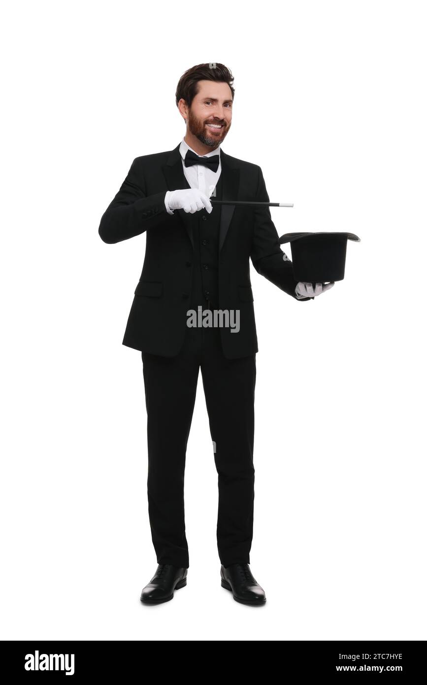Happy magician showing magic trick with top hat on white background ...