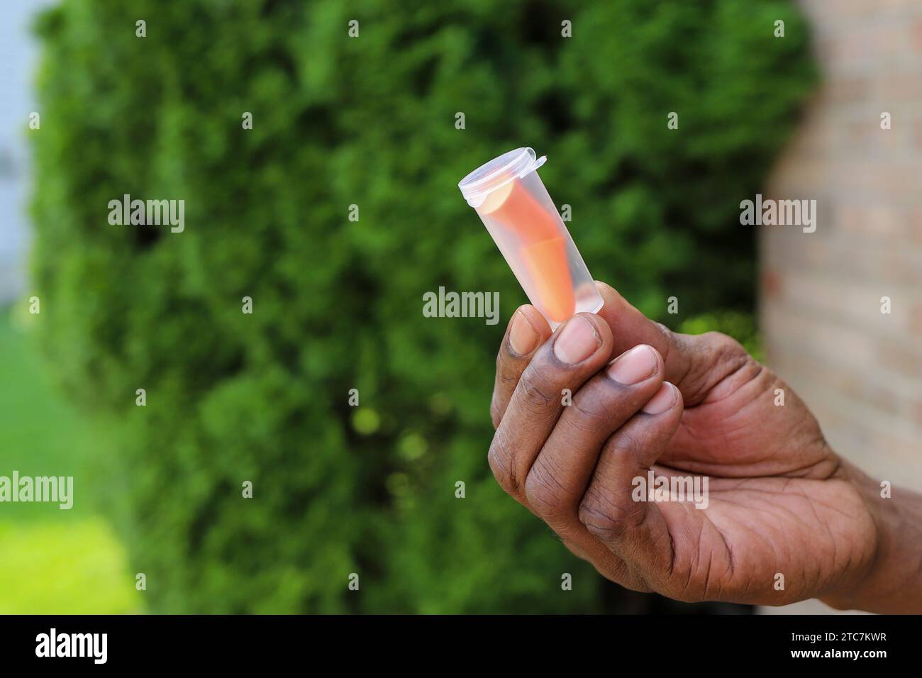 A close up of black AfricanAmerican man holding ear plugs in his hand