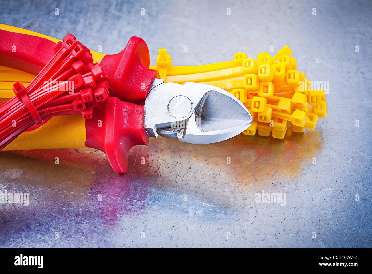 Nippers plastic tying cables on scratched metallic background Stock Photo