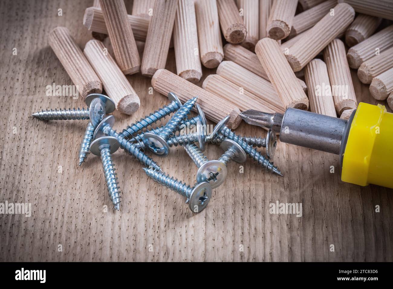 Wooden dowels construction nails and insulated screwdriver on wood board Stock Photo Alamy