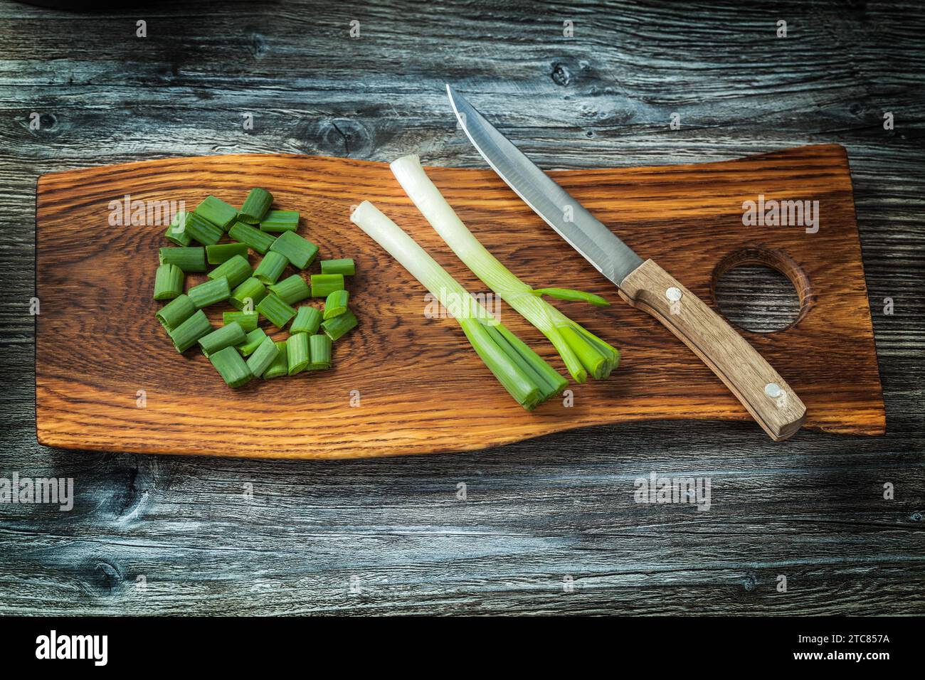 Chopped onion stems and kitchen knife on wooden copping board vintage ...
