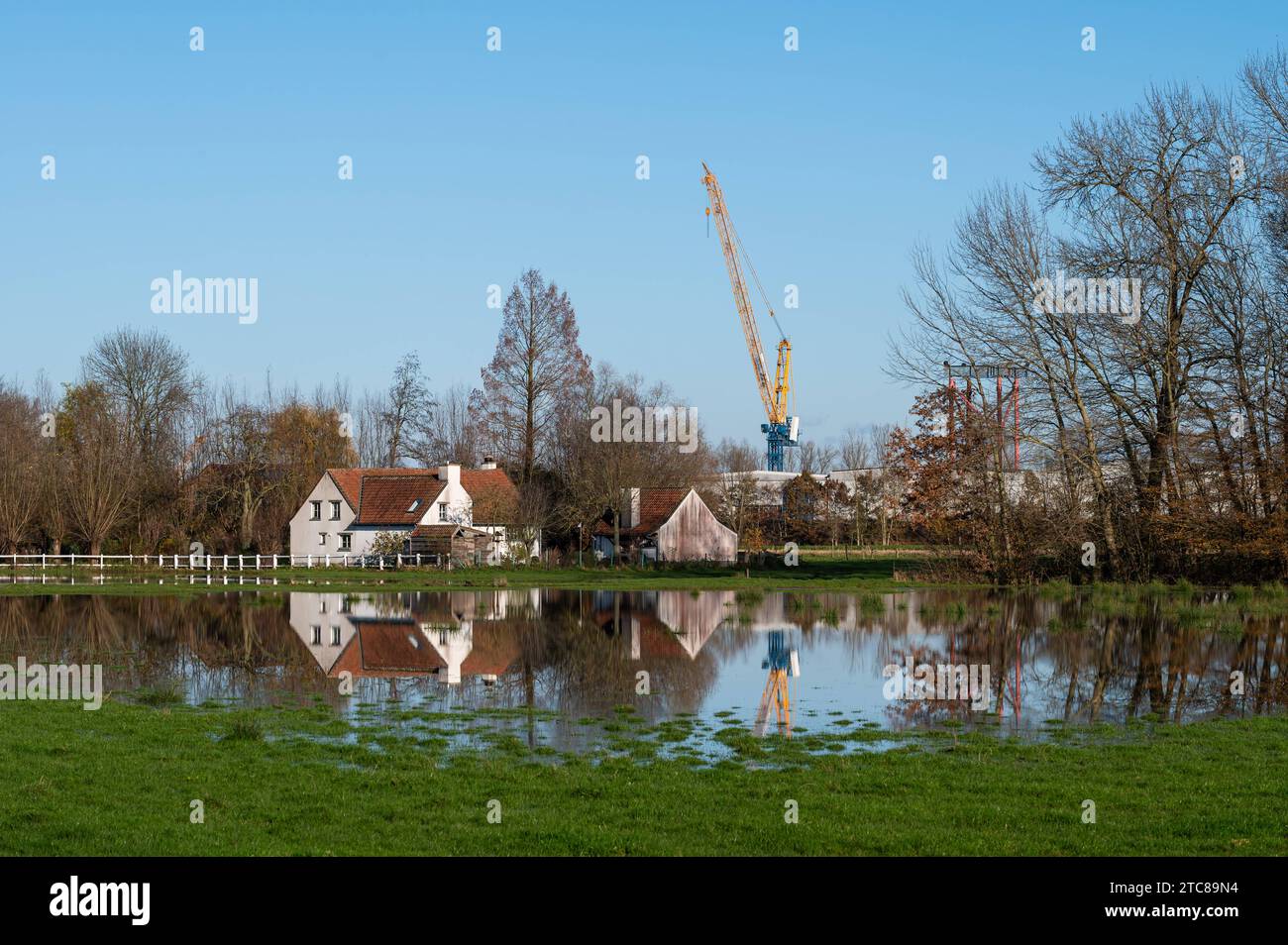 Imde, Meise, Flemish Brabant Region, Belgium, November 28, 2023 - Construction crane and houses reflecting in a flooded meadow Credit: Imago/Alamy Live News Stock Photo