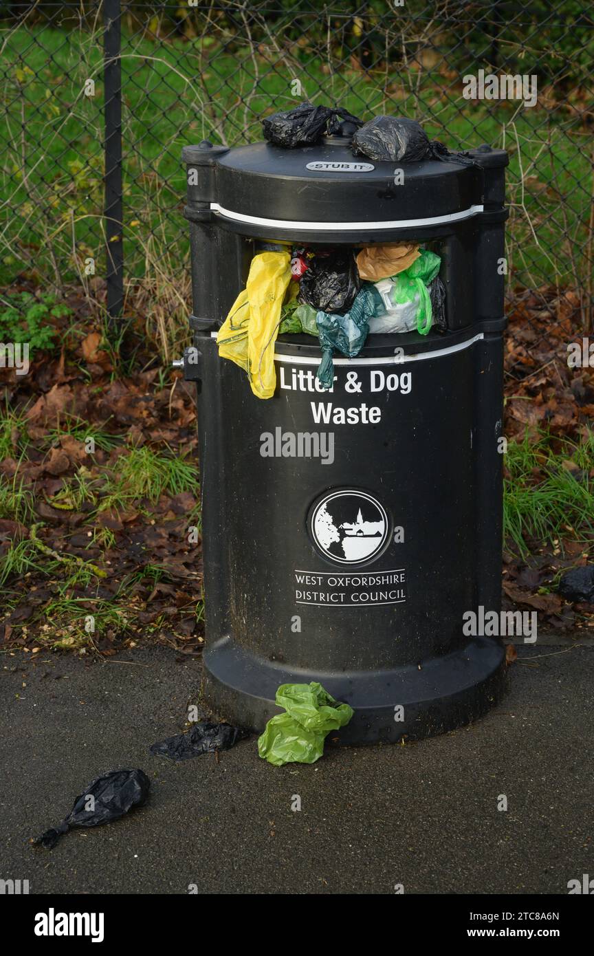 Litter and dog waste bin overflowing with plastic poo bags, UK Stock Photo Alamy