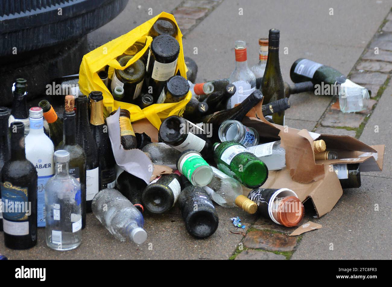 Copenhagen, Denmark /11 December 2023 /Empty wine bottle pile infront of recycle container