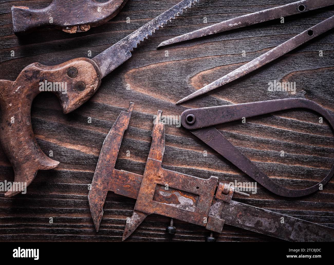 Rusted vintage calipers hand saw and claw hammer on vintage wooden ...