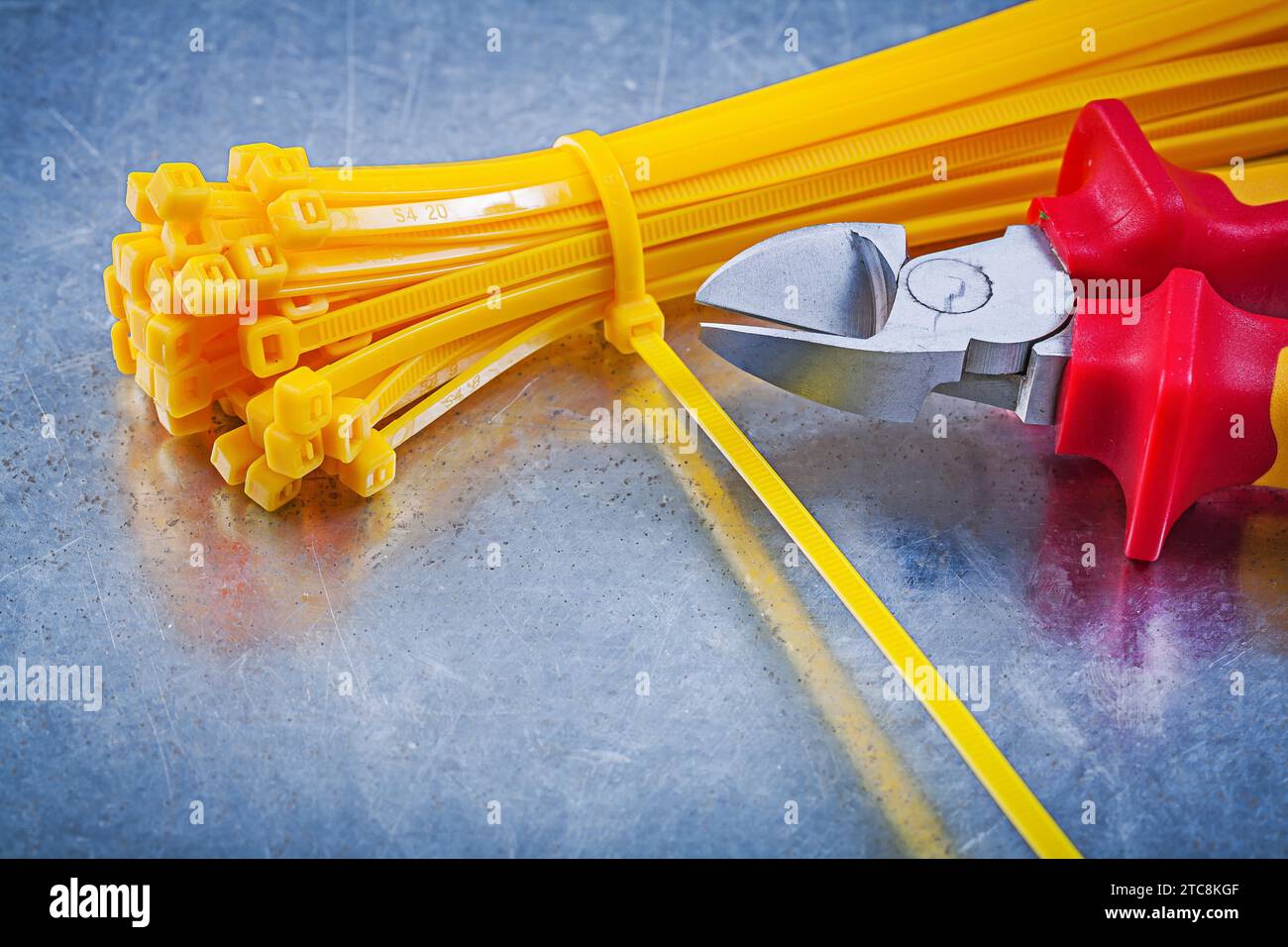 Cutting pliers cable ties on metallic background construction concept Stock Photo