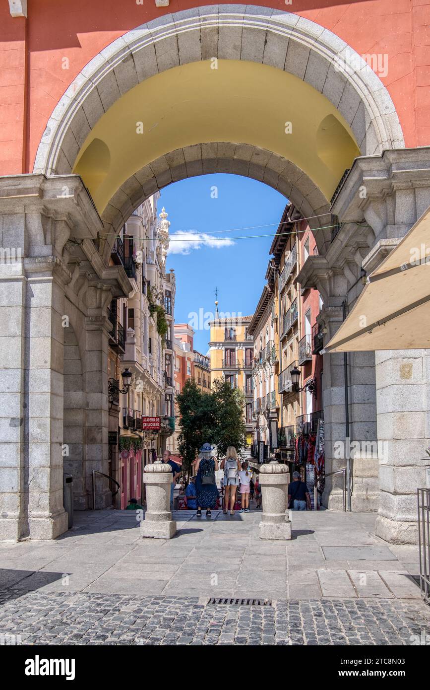 Madrid, Spain - August 28, 2023:  Exiting the historic Plaza Mayor on to the charming old streets of central Madrid Stock Photo