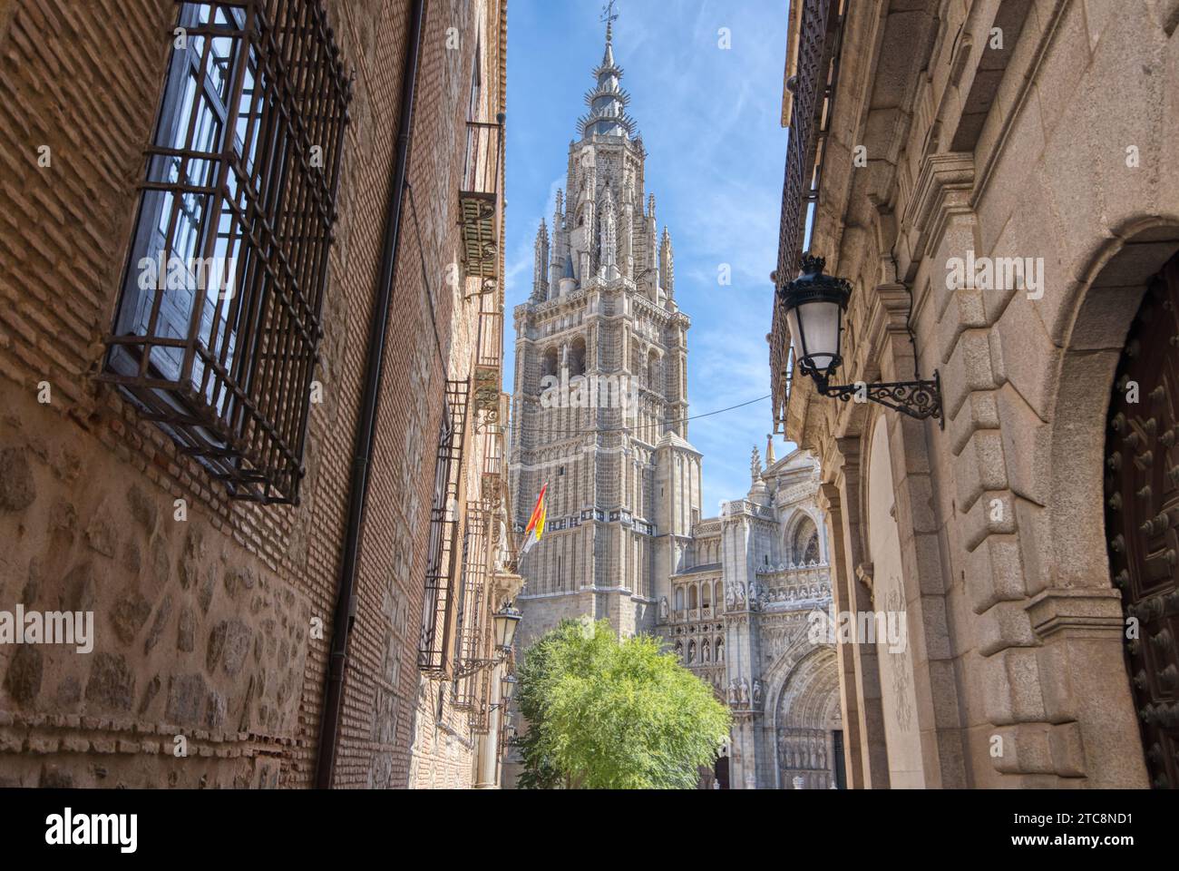The 13th century Primatial Cathedral of Saint Mary of Toledo appears through the streets in historic Toledo, Spain Stock Photo