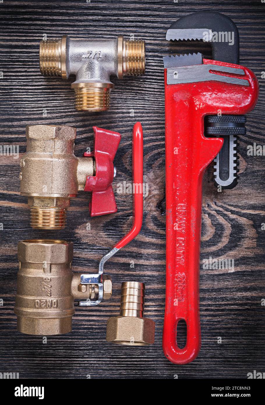 Composition of pipe wrench brass fittings water valve on wood board