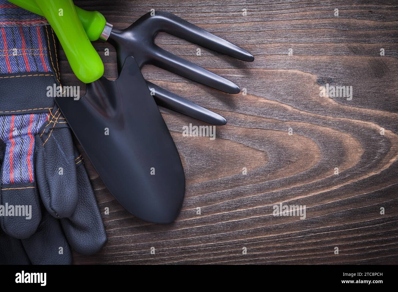 Gardening safety gloves hand spade and trowel fork on vintage wood