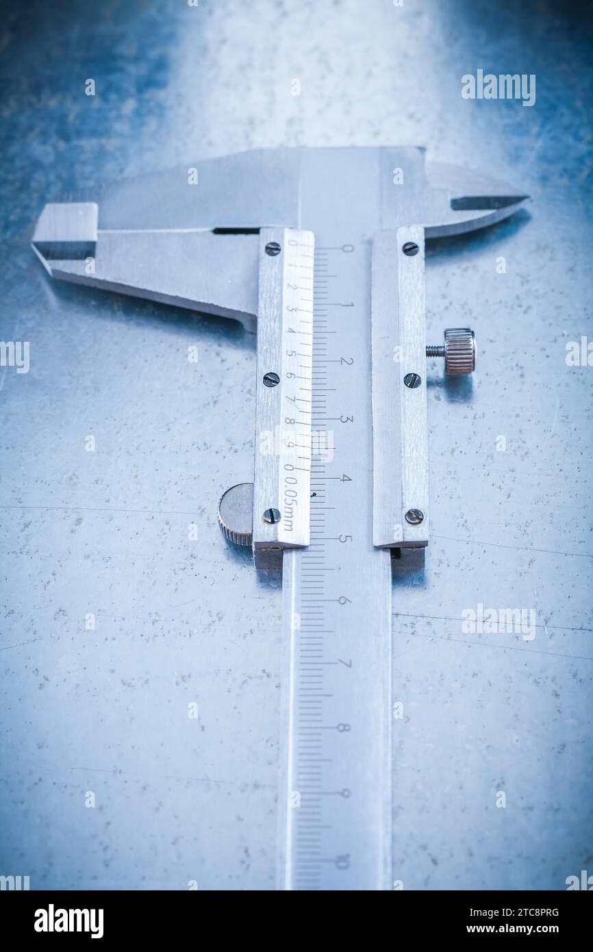 Metal slide caliper on metallic background vertical view construction concept Stock Photo