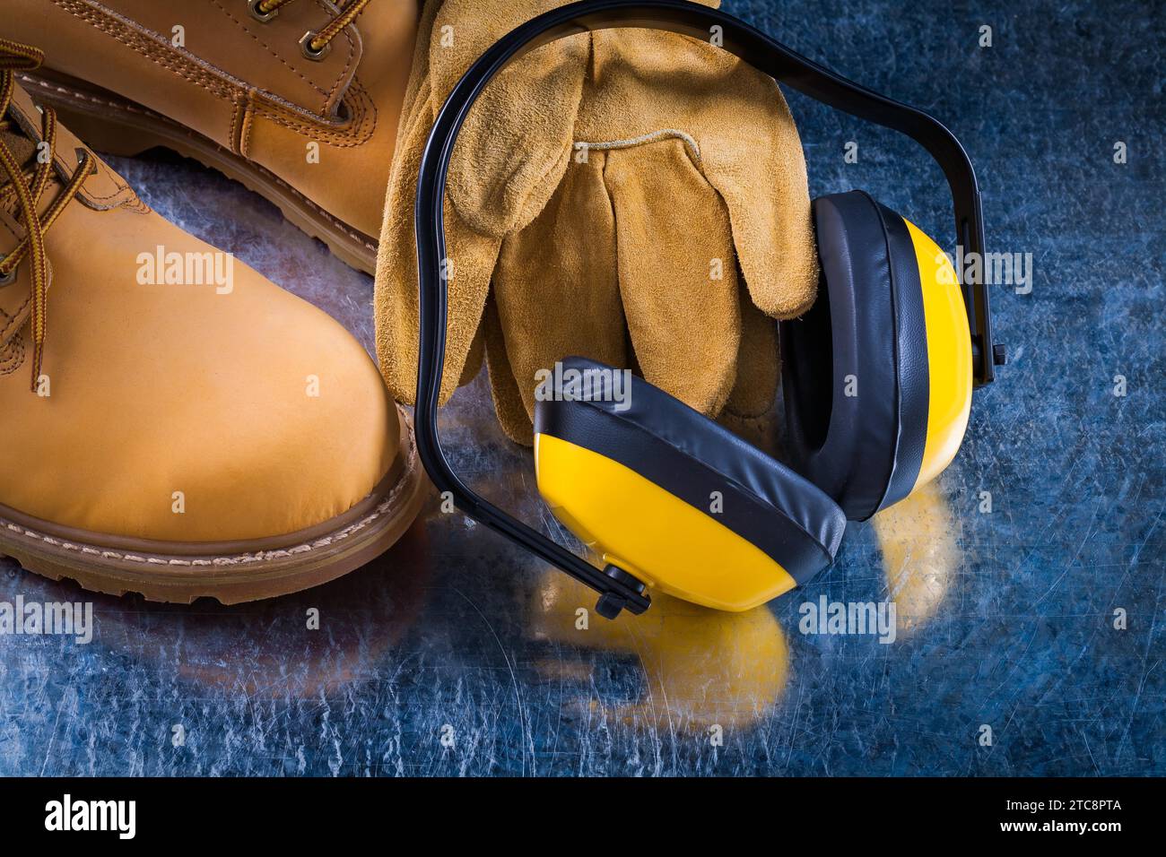 Leather working lace boots protective gloves and earmuffs on scratched