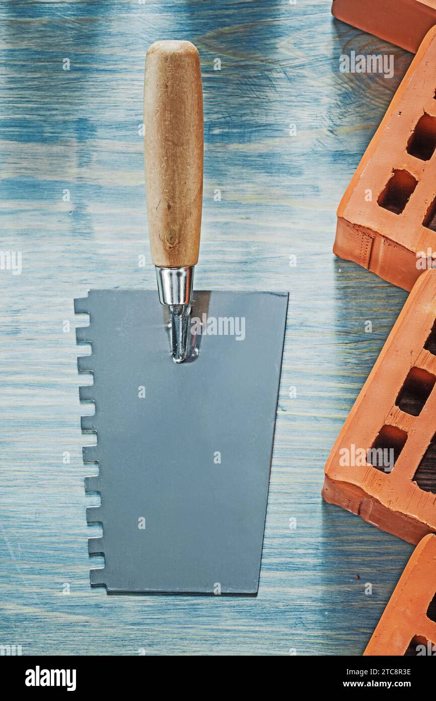 Plastering trowel red bricks on wood board bricklaying concept Stock Photo
