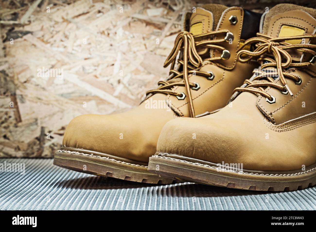 Brown work boots on plywood background Stock Photo