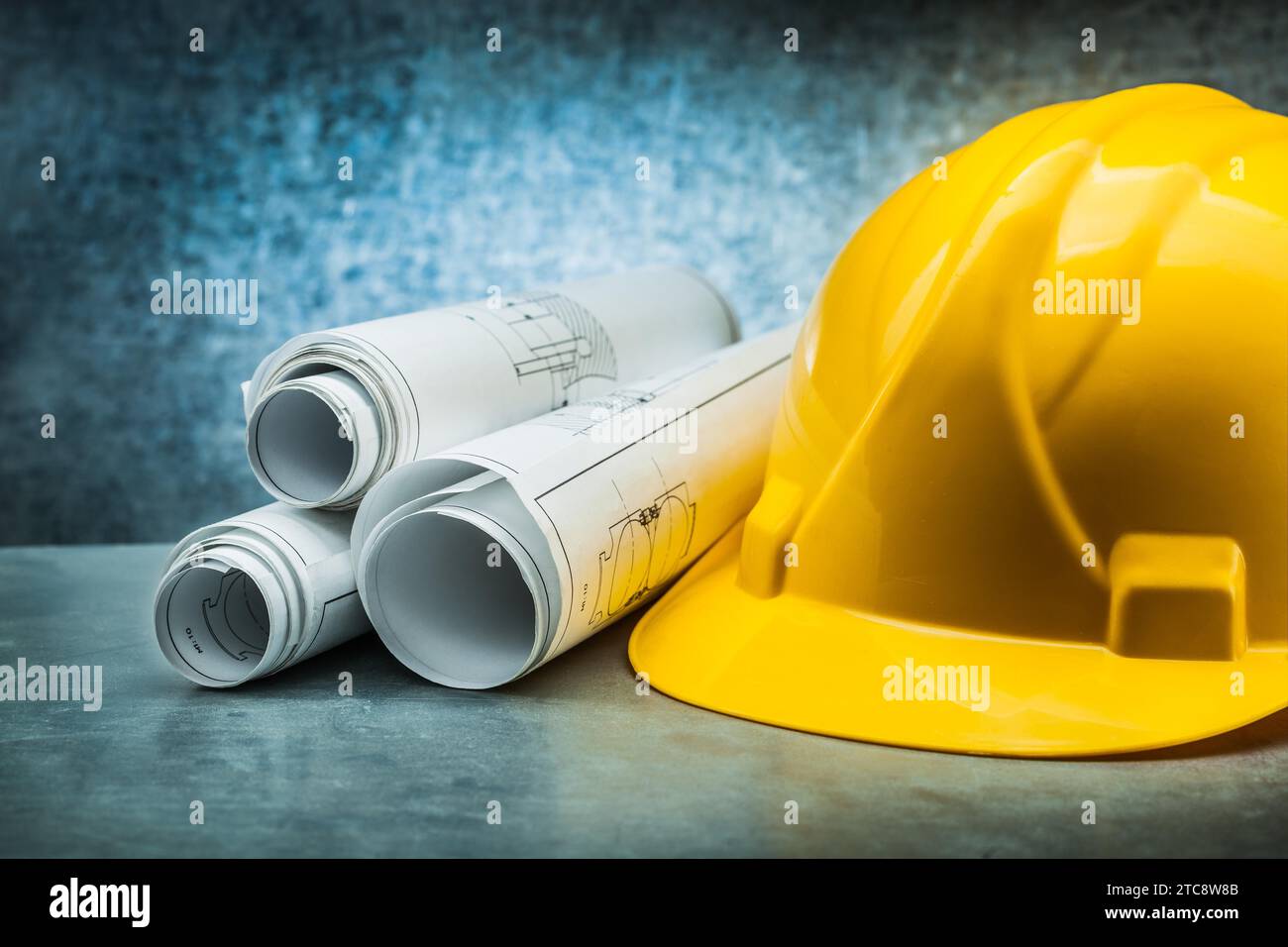 Construction helmet rolled blueprints on metallic background Stock ...