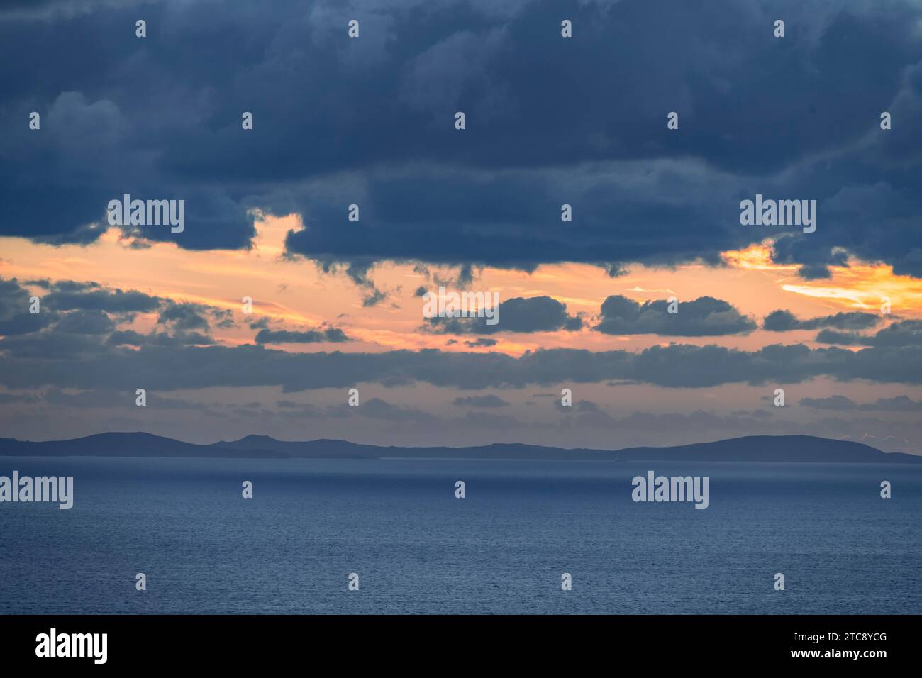 Dramatic cloudy sky at sunrise over the sea, Aegean Sea, Syros, Cyclades, Greece Stock Photo