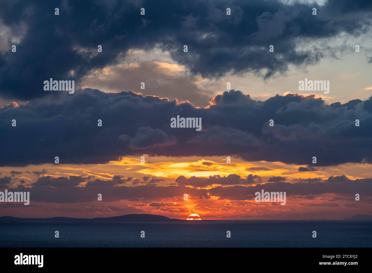 Dramatic cloudy sky at sunrise over the sea, Aegean Sea, Syros, Cyclades, Greece Stock Photo