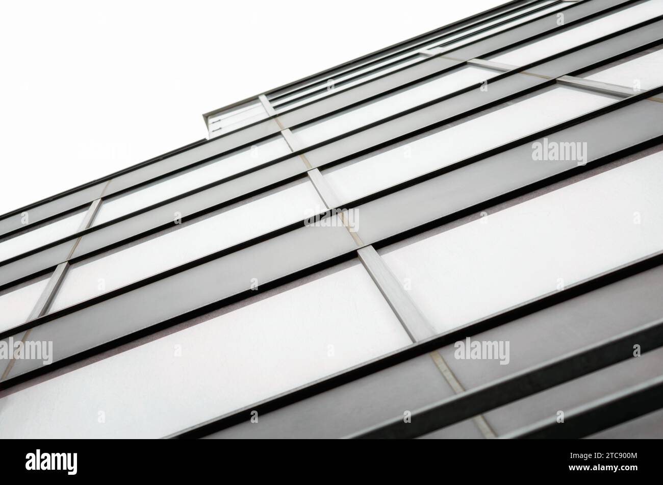Fragment of the wall and windows of a modern tall office building without people abstract architectural monochromatic background Stock Photo