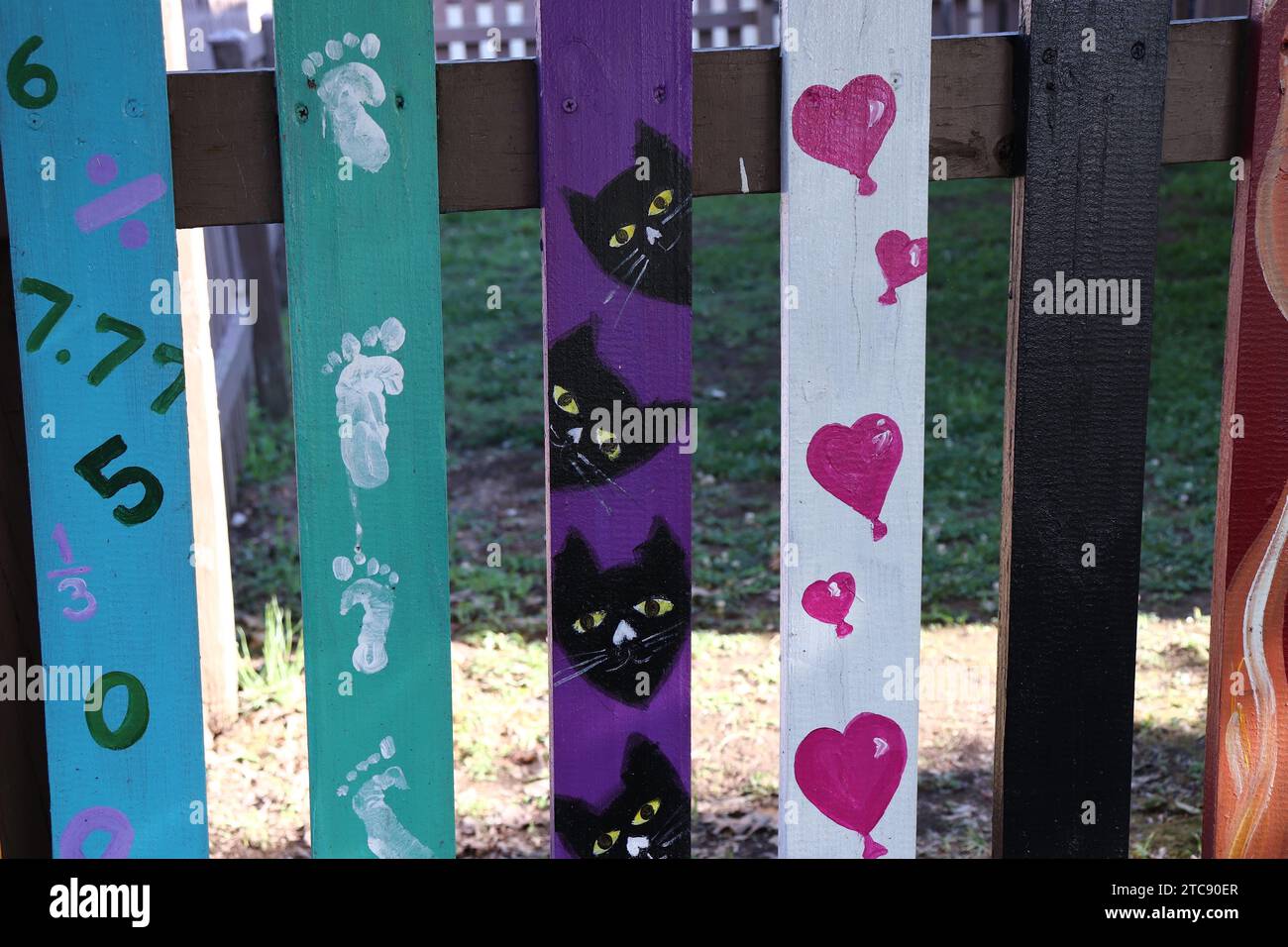 Whimsical and Colorful Paintings on Wooden Fence Slats Stock Photo