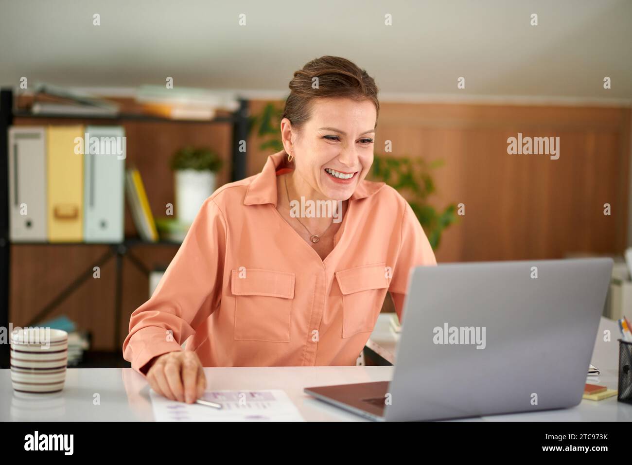 Portrait of mature woman laughing at memes on laptop screen in stead of  working Stock Photo - Alamy, image size:1300x956