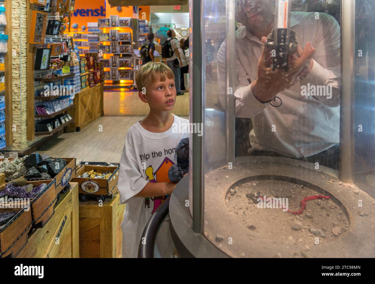 A toy store employee shows a child how to use the geode smasher at the FAO Schwarz store in Manhattan. Stock Photo