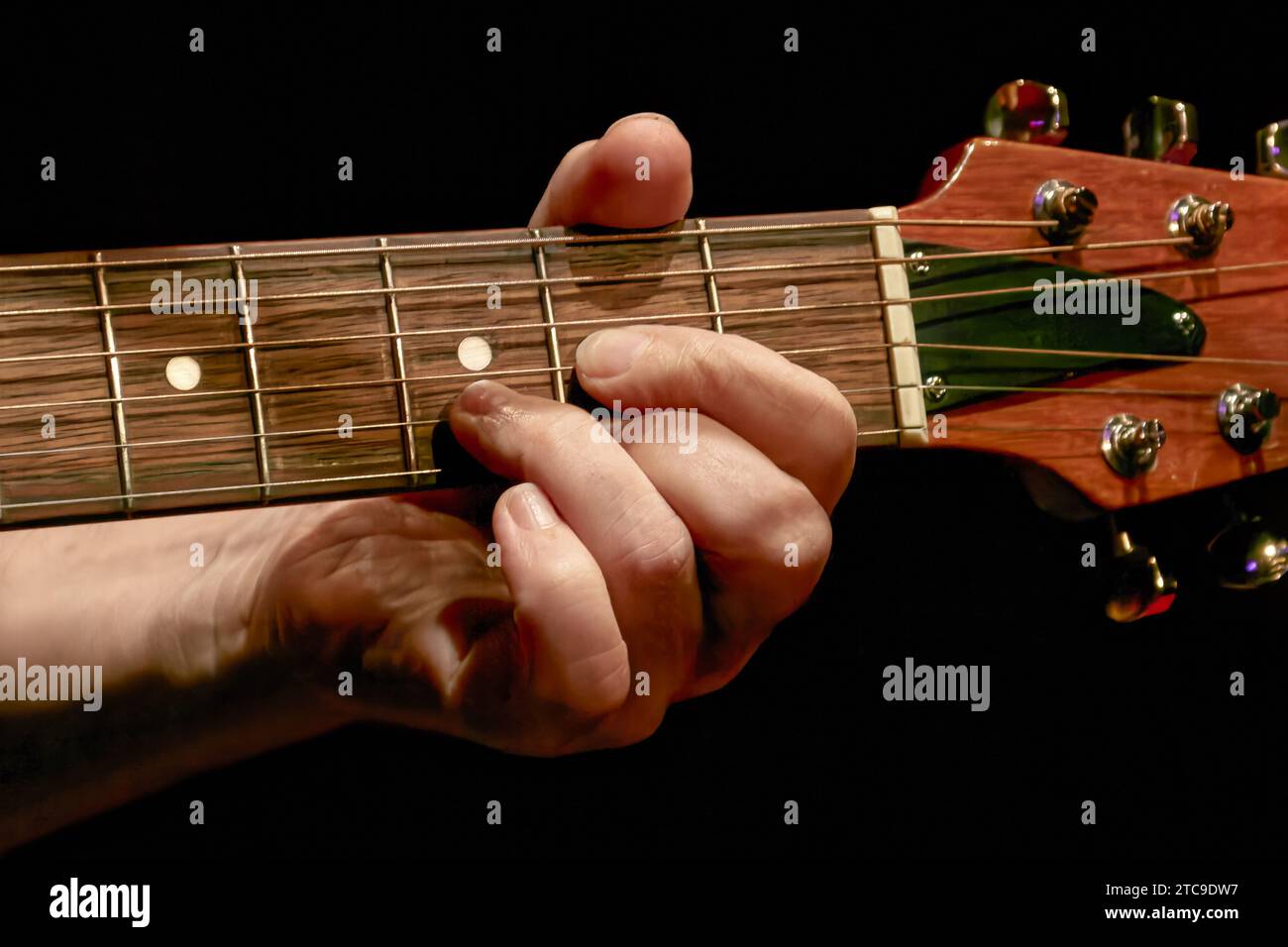 Image of a musician's fingers playing a chord on a guitar neck Stock