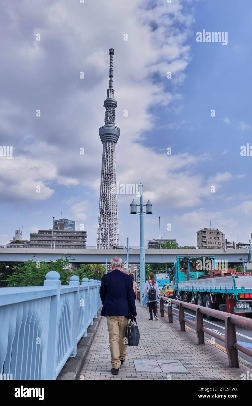 Tokyo Japan; May 13, 2019: A man dressed in business style walks towards the Tokyo Sky Tree. Stock Photo