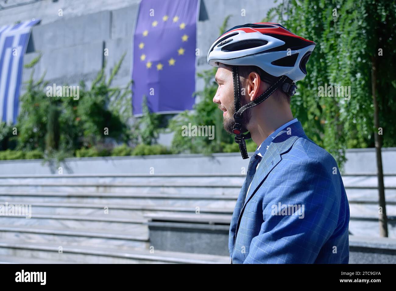 Businessman in helmet with european union flag on wall. Business and urban style concept. Close up Stock Photo