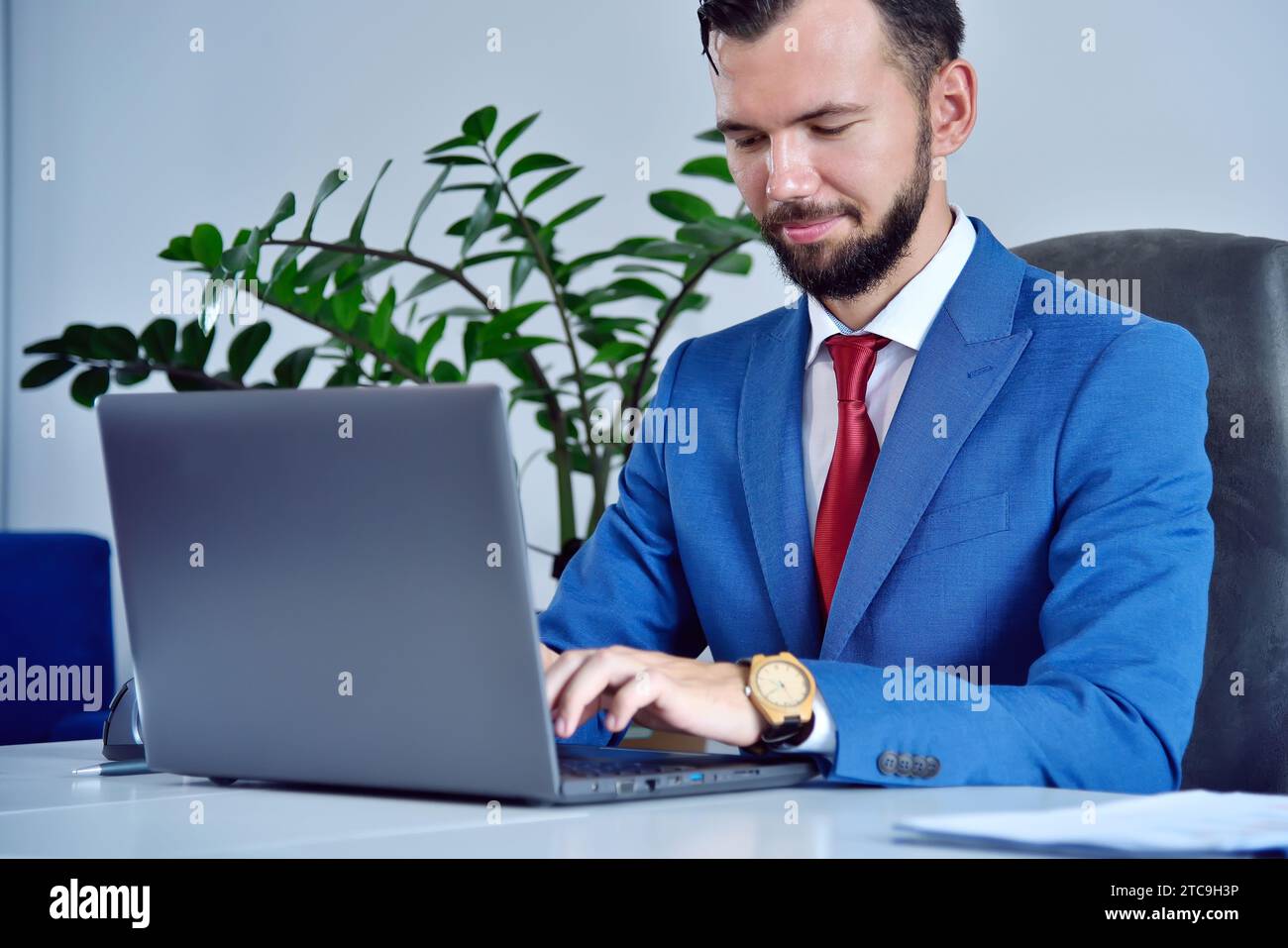 Office manager with wooden watch typing on laptop keyboard. Occupation and worker concept. Close up Stock Photo