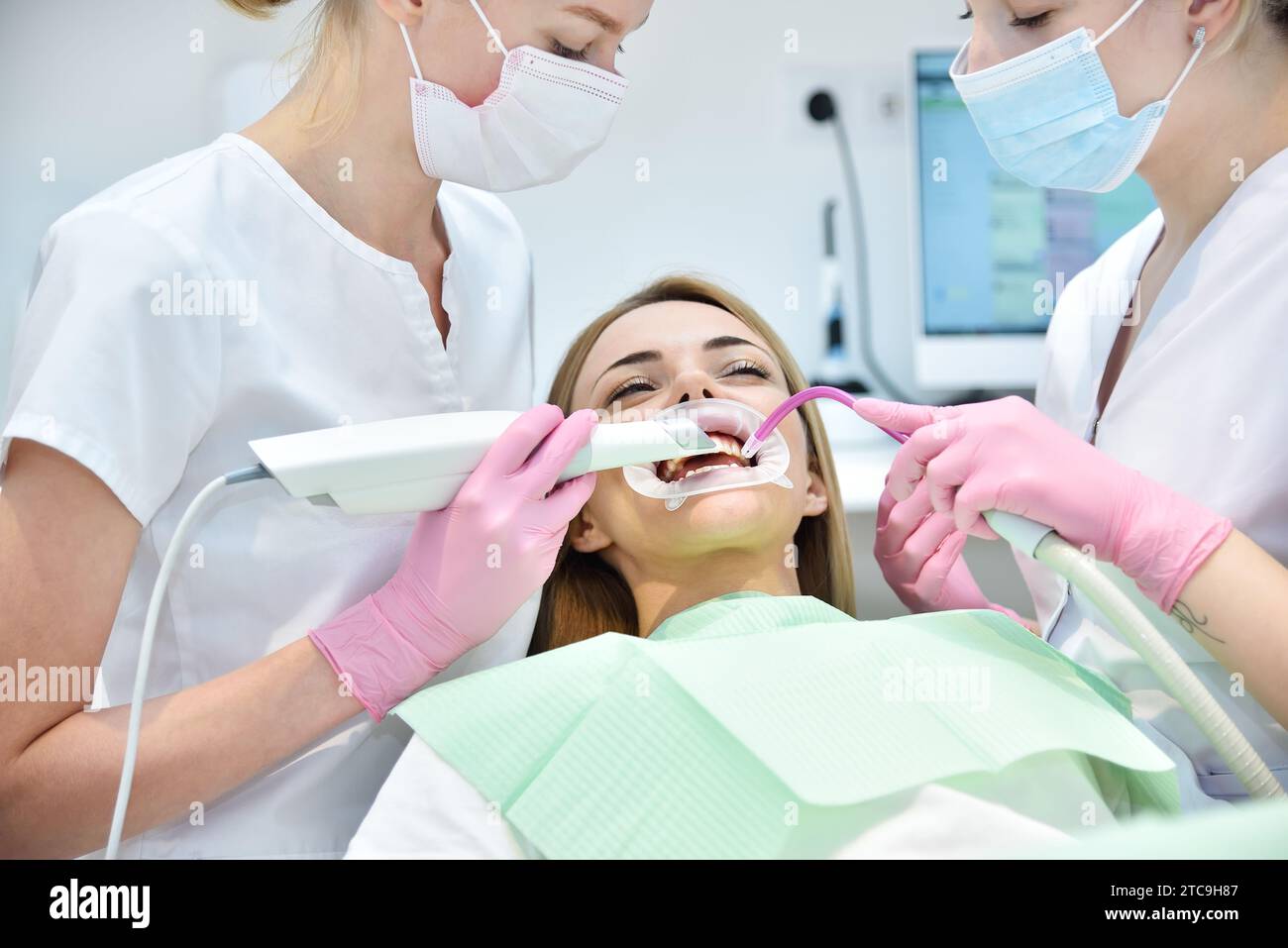 Dentist and assistant scaning patient's teeth with  3d scanner. Healthcare and stomatology concept Stock Photo