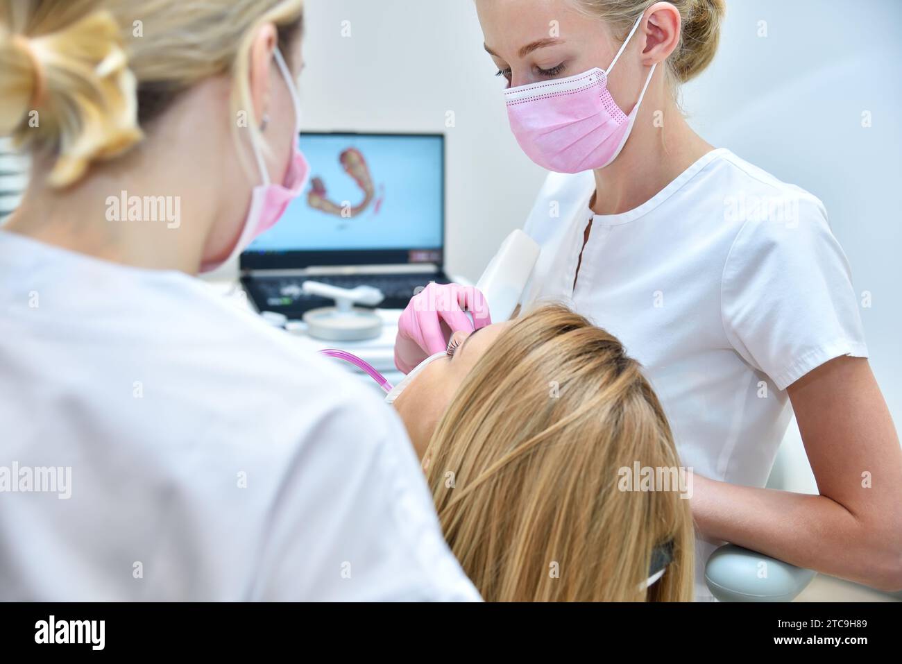 Orthodontist and assistant scaning patient's teeth with 3d scanner. Health care and stomatology concept Stock Photo