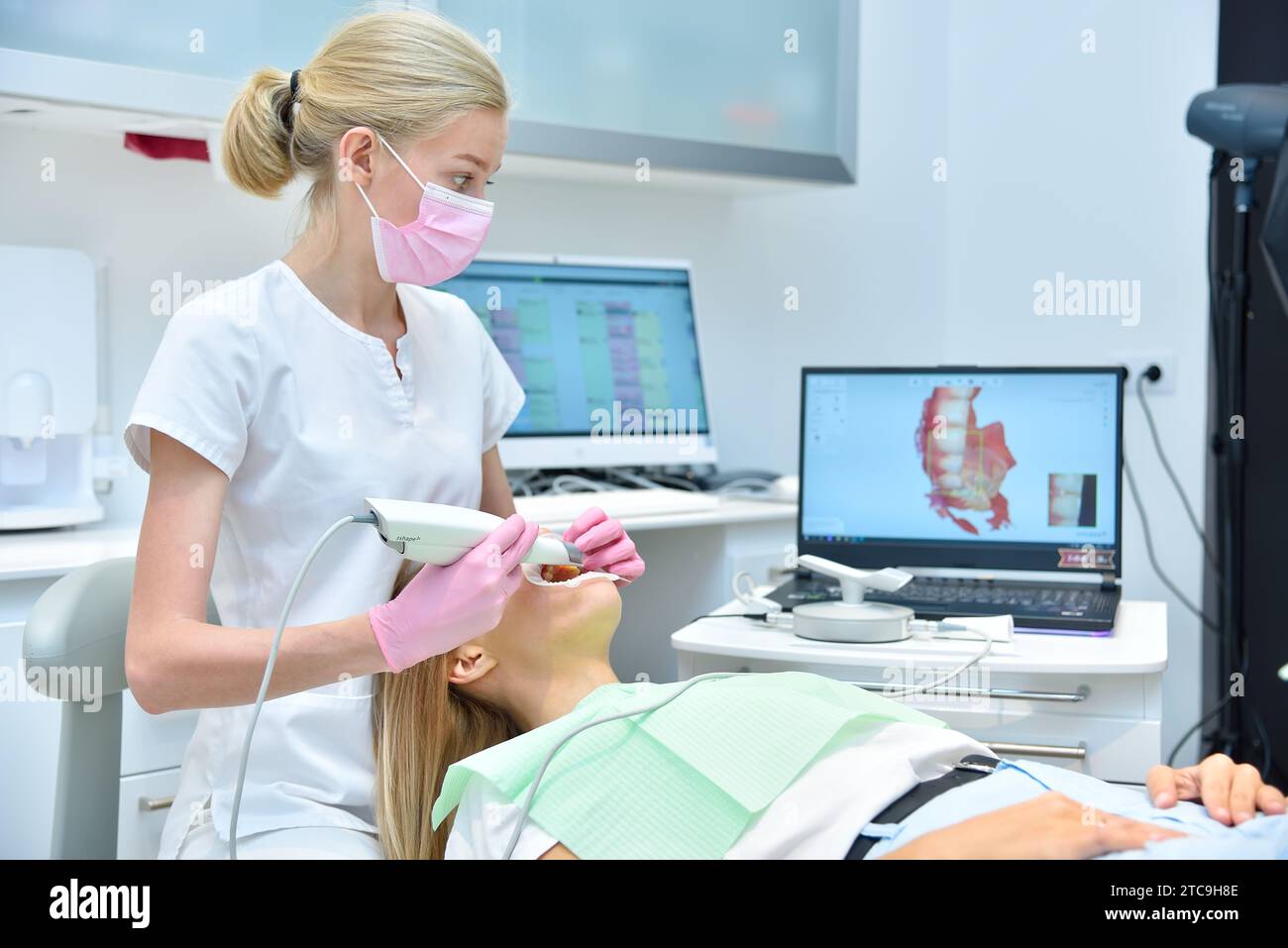 Orthodontist scaning patient with dental intraoral scanner and controls