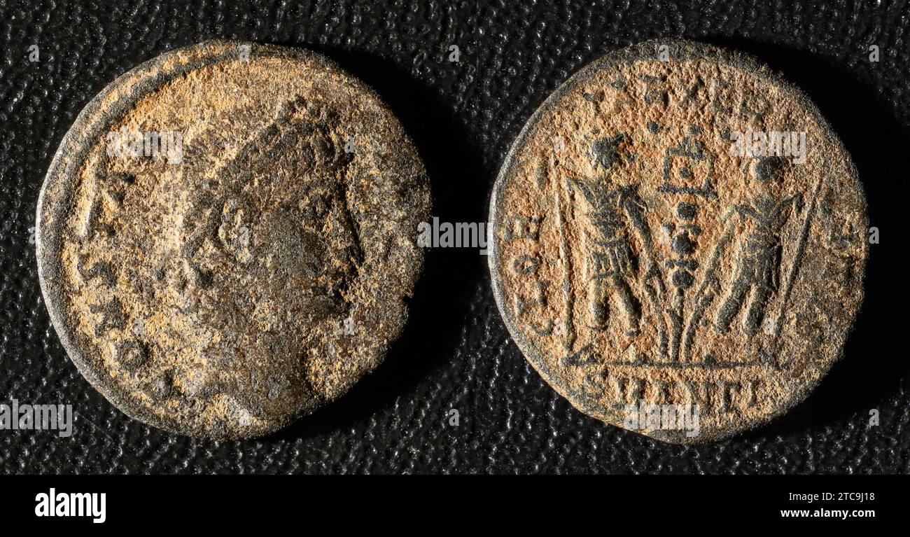 Ancient Roman coin of Emperor Constantius II, top view of vintage metal money isolated on black background. Theme of old grungy copper texture, Rome, Stock Photo