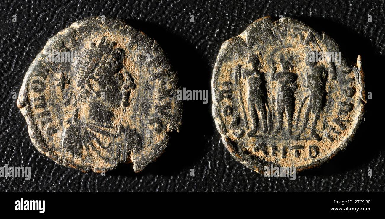 Ancient Roman coin of Emperor Honorius, old damaged metal money isolated on black background. Theme of vintage copper or bronze texture, Rome, Empire, Stock Photo