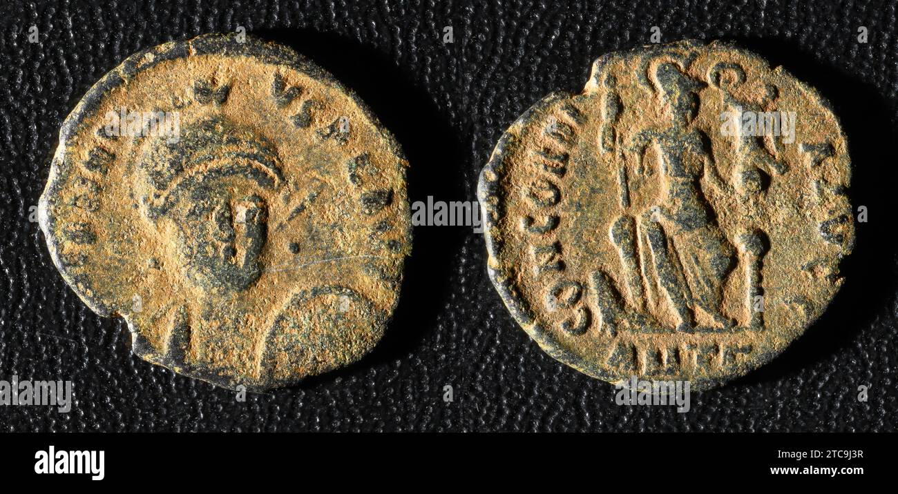 Ancient Roman coin of Emperor Honorius, old worn metal money isolated on black background. Theme of vintage copper texture, Rome, Empire, antique and Stock Photo