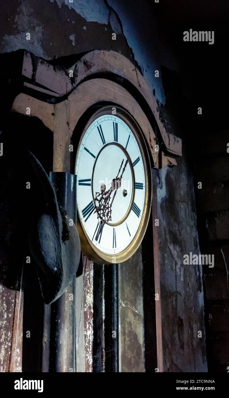 An antique clock is mounted to the wall, with a hat casually placed ...