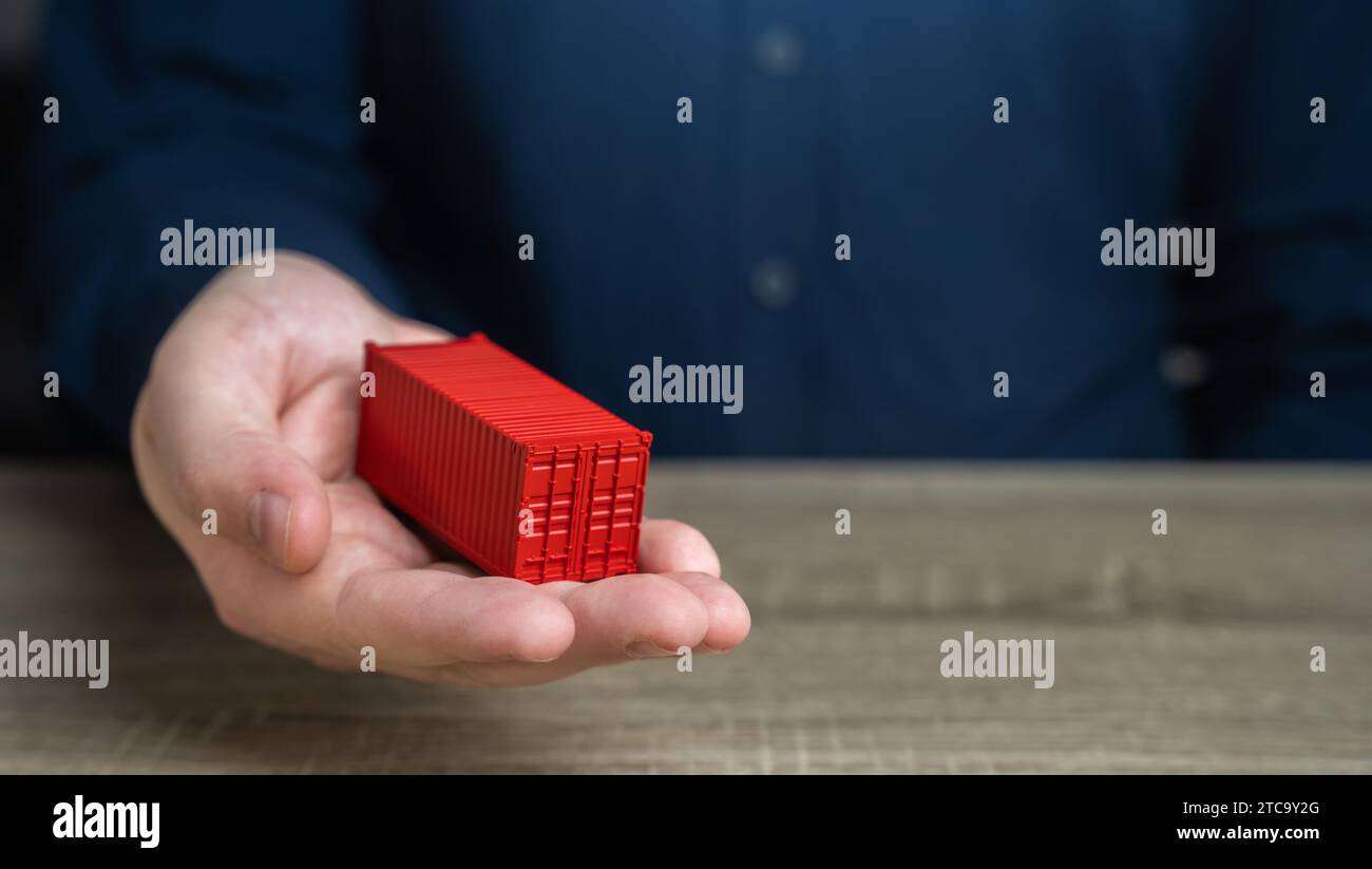 A man holds a red shipping containers in his hand. Cost savings due to