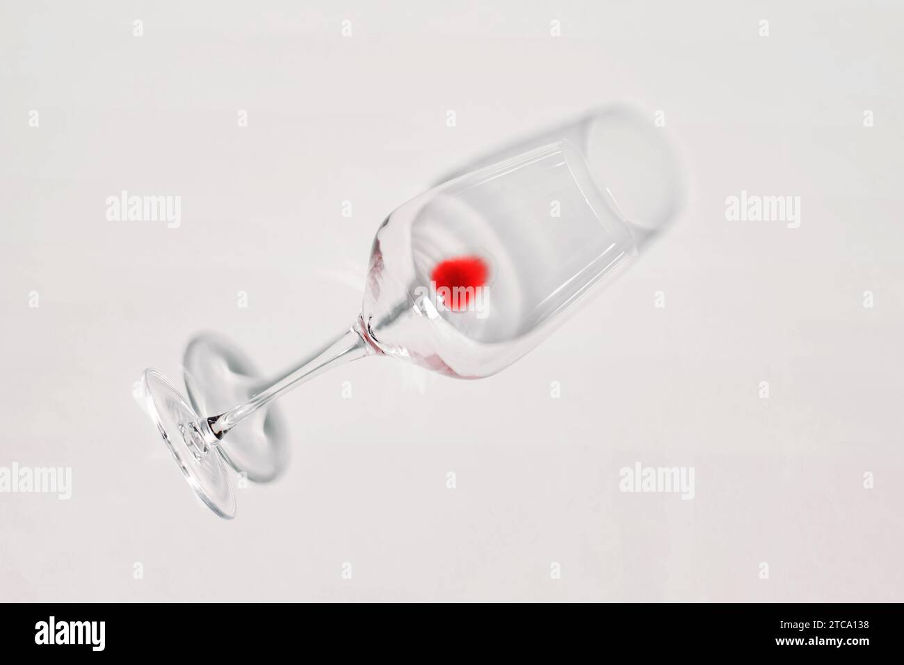 Wine glass with drop of red wine left, isolated on white. Dry january, quit drinking, alcohol problems concept, Stock Photo