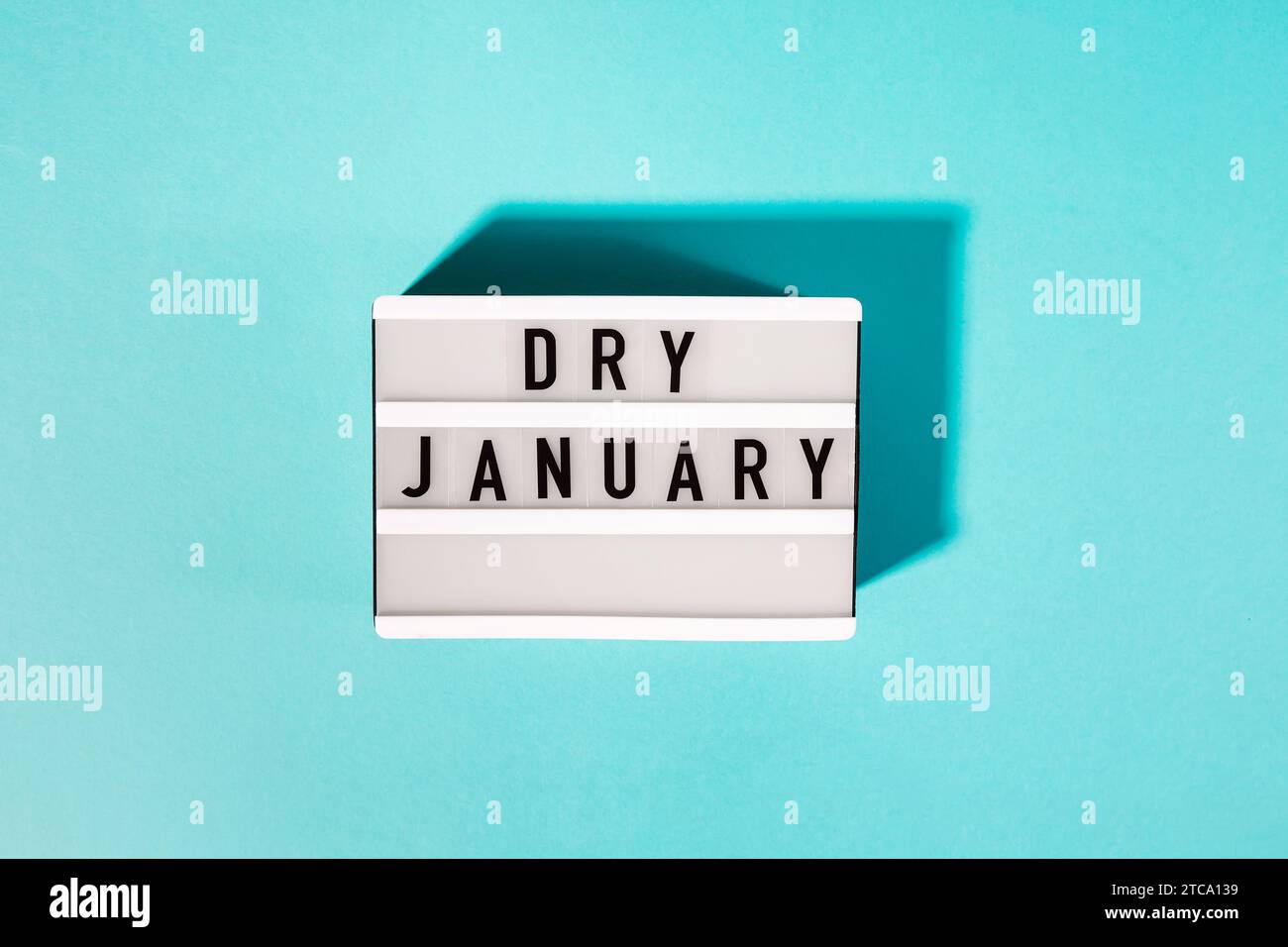 Text Dry January on the decorative lightbox isolated on blue background, top view. Mindful drinking Stock Photo
