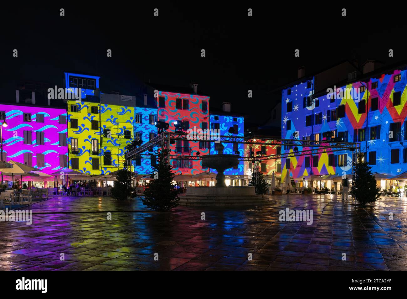 Udine, Italy (Dec-2023) - Piazza Matteotti square during Christmas holidays with a colourful mapping on the facades of the buildings Stock Photo