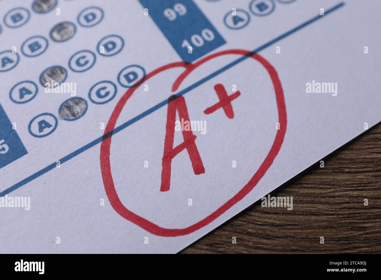 School grade. Answer sheet with red letter A and plus symbol on wooden ...