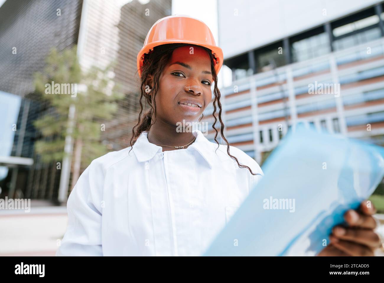 Smiling African American female inspector checking construction documents Stock Photo