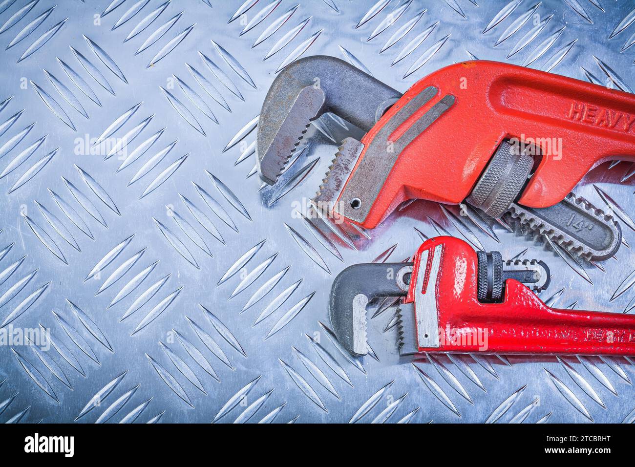 Composition of monkey spanners on a grooved metal background Design concept Stock Photo