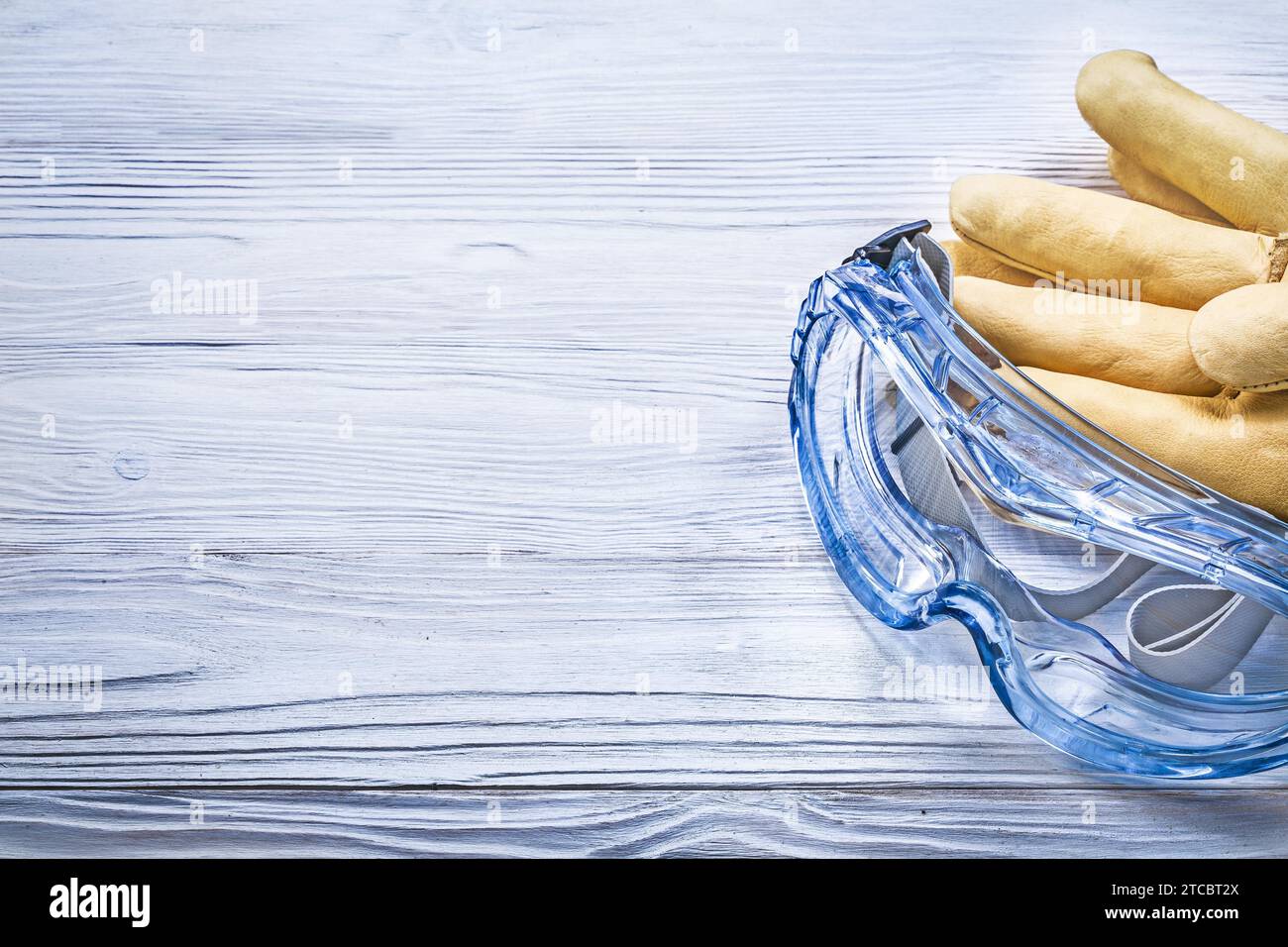 Safety goggles Gloves on wooden board Copy of room Construction concept Stock Photo