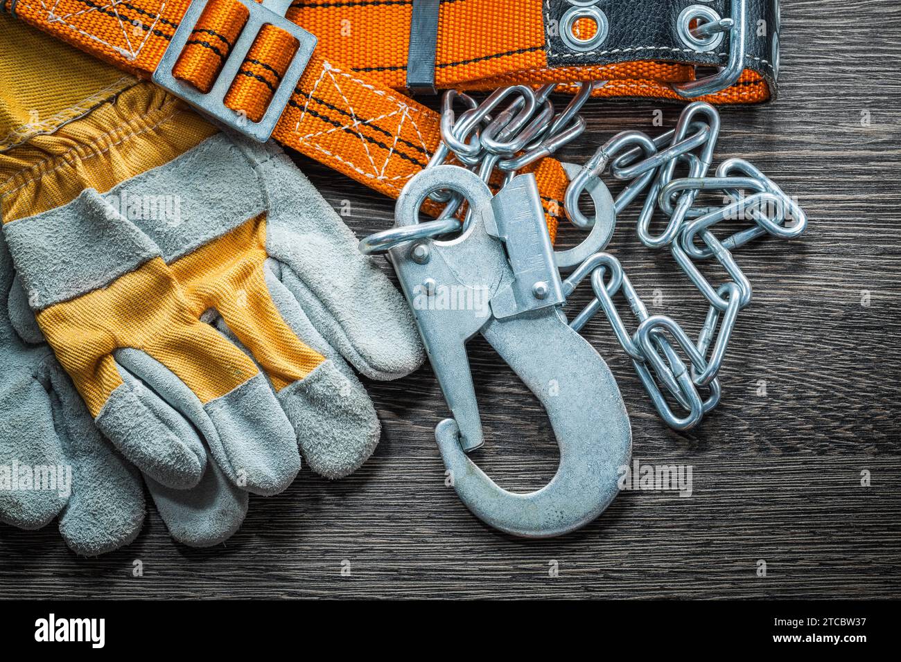 Composition of safety gloves Construction body belt on wooden board Stock Photo