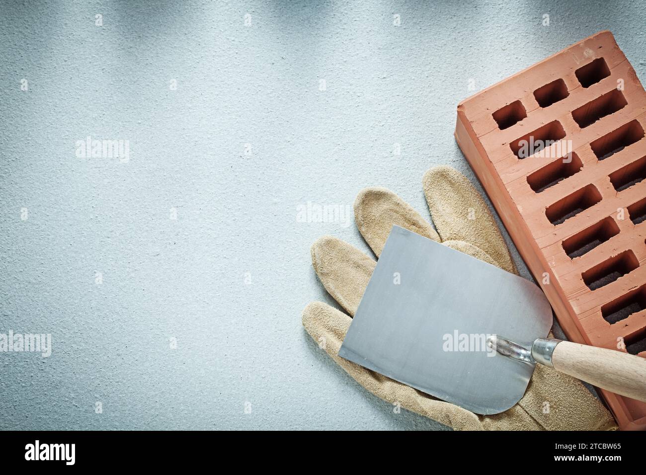 Construction brick leather protective gloves plastering trowel on concrete surface bricklaying concept Stock Photo