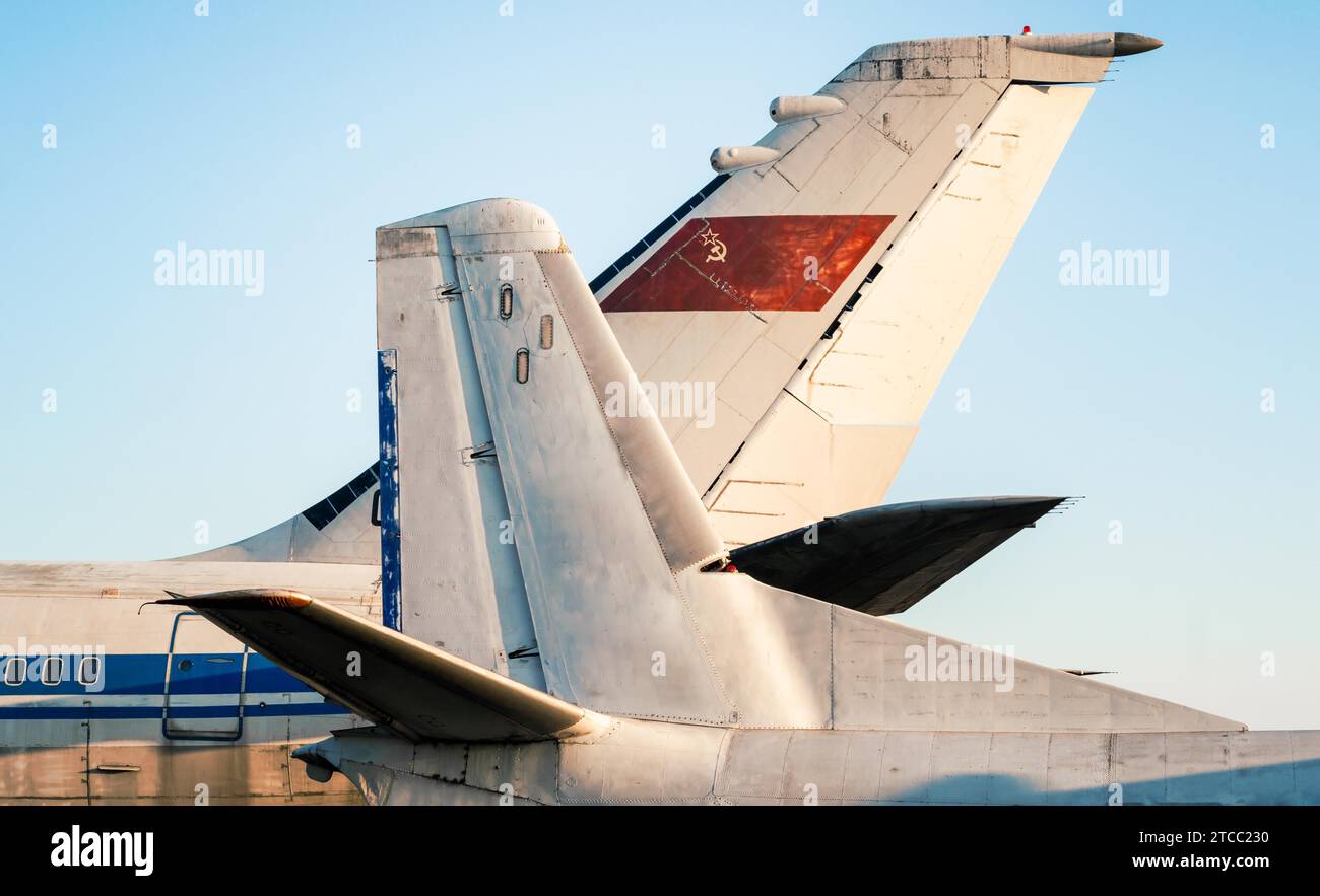 Tail and wings of large old airliners with the symbol of the Soviet Union isolated on a blue sky background Stock Photo
