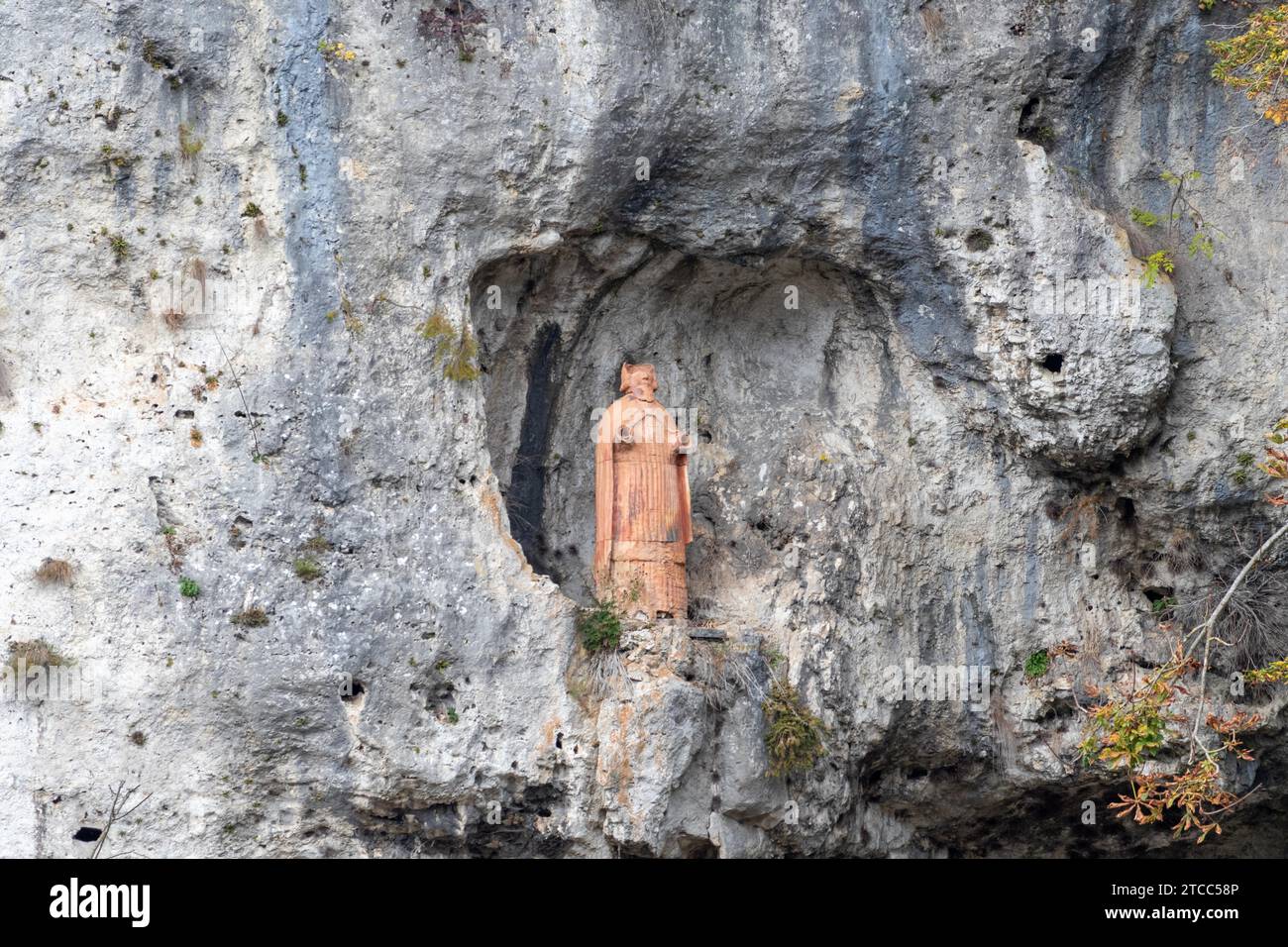 Terracotta statue of St. Nicholas in the rock near franciscan monastery Kloesterl near Kelheim, Bavaria, Germany Stock Photo