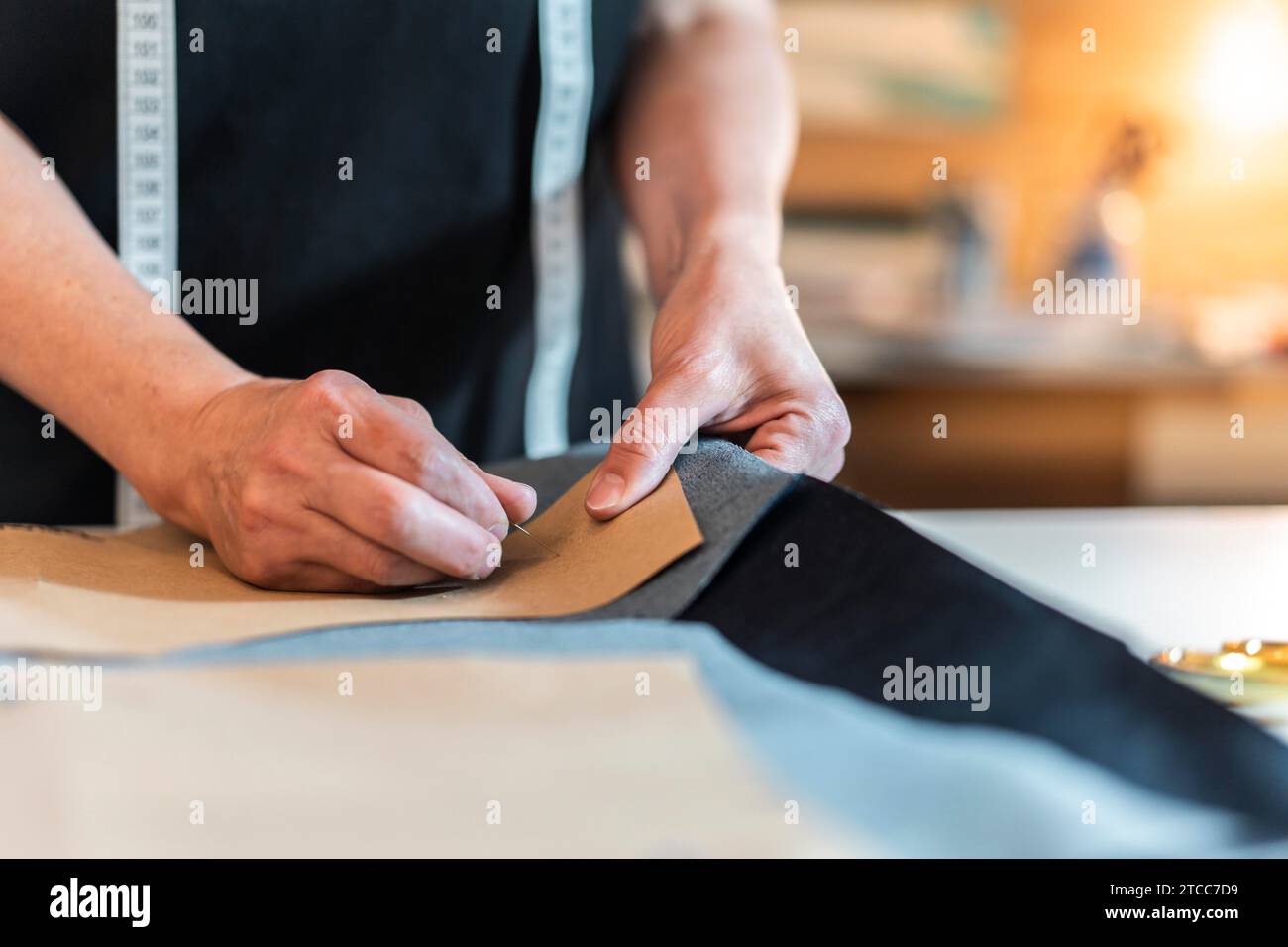 Fashion designer putting pins into pattern and fabric Stock Photo
