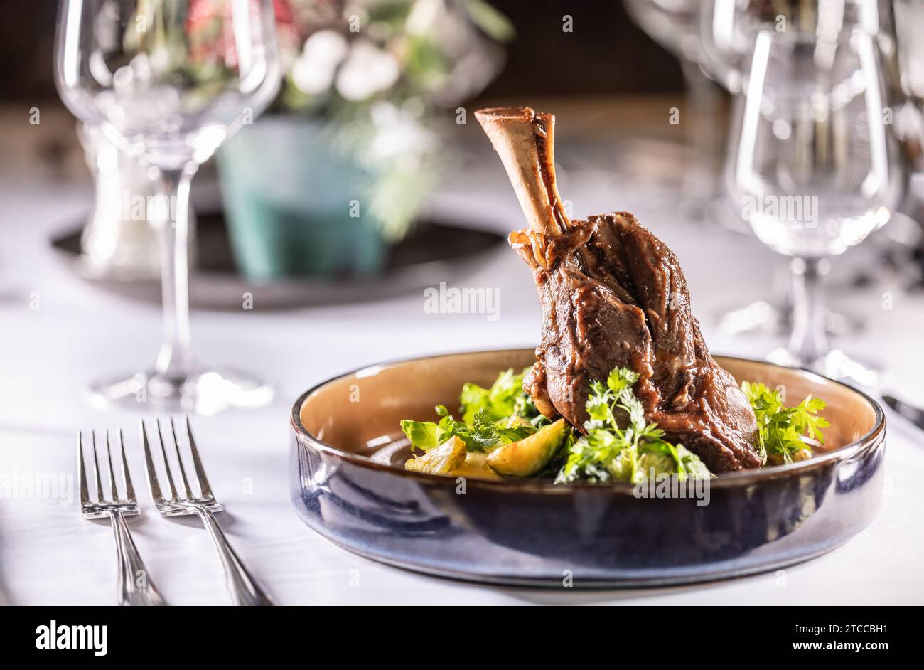 Confit leg of lamb on mashed potatoes with creamy kale, demi glace sauce and herbs in the hotel